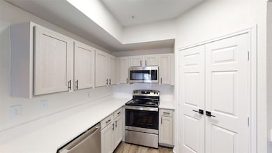 Kitchen with light wood-type flooring, appliances 