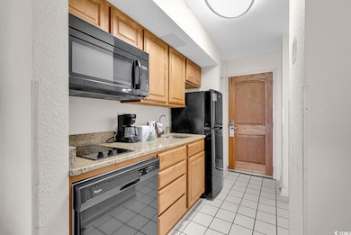 Kitchen with a sink, black appliances, and light t