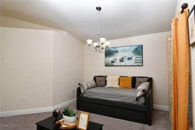 Family room featuring vaulted ceiling, a chandelier, a textured ceiling, and carpet flooring