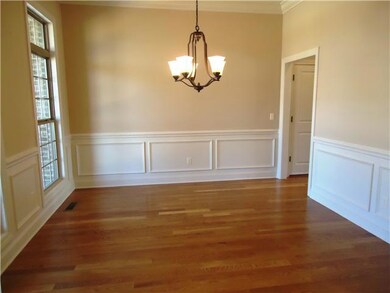 The large dining room has a chandelier, crown molding and wainscotting. It is convenient to the kitchen. 