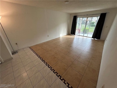 Tiled empty room with a textured ceiling