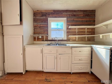Kitchen with light countertops, light wood finished floors, white cabinets, and open shelves
