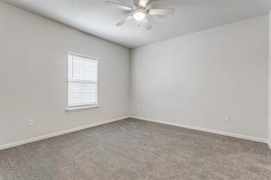 Spare room featuring light colored carpet and ceiling fan