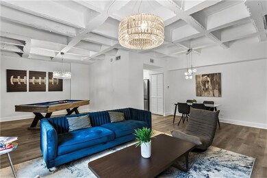 Living room featuring coffered ceiling, beamed ceiling, dark wood-style floors, a chandelier, and billiards