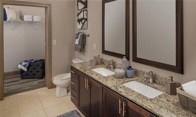 Bathroom featuring dual bowl vanity, hardwood / wood-style flooring, and toilet