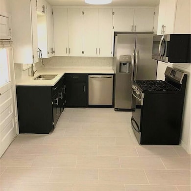 Kitchen with a sink, tasteful backsplash, stainle