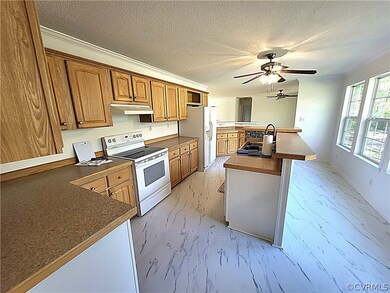 Kitchen with kitchen peninsula, white appliances, ceiling fan, a textured ceiling, and sink