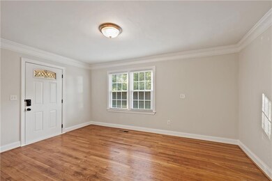 Foyer featuring light wood-style floors and ornamental molding