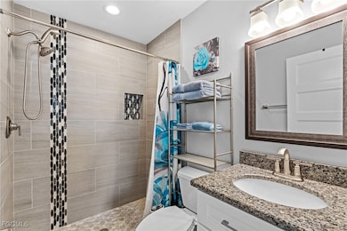 Bathroom featuring a stall shower, vanity, and rec