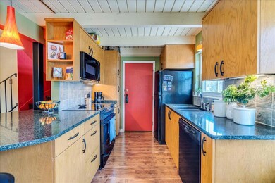 Kitchen with black appliances, a sink, open shelv