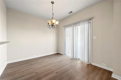 Spare room with visible vents, baseboards, wood fi