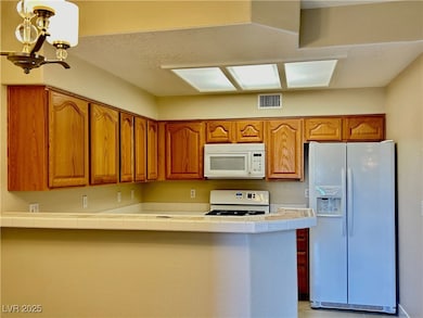 Kitchen with visible vents, a notable chandelier,