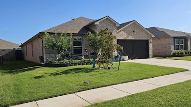 View of front of property with a garage, concrete driveway, brick siding, and roof with shingles