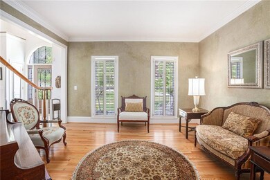 Sitting room with crown molding, wood finished flo