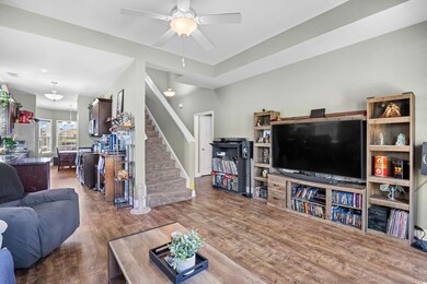 Living room featuring stairs, wood finished floors, and a ceiling fan