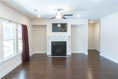 Unfurnished living room with ceiling fan and dark 