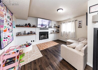 Living room with a textured ceiling and dark hardw