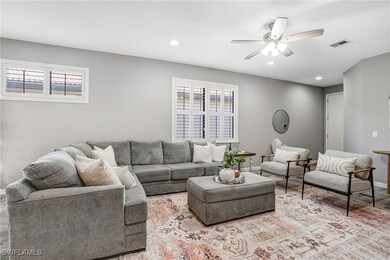 Living room featuring a ceiling fan, plenty of nat