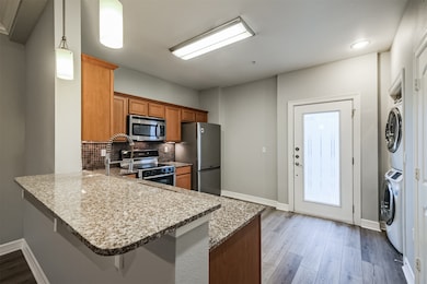 View from living/dining area into gourmet kitchen with access to front door/gate to small front gated yard