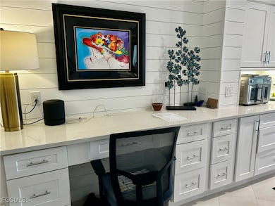 Kitchen with white cabinetry, light stone countertops, and light tile patterned floors