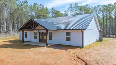 View of front of home with metal roof, a patio, a 