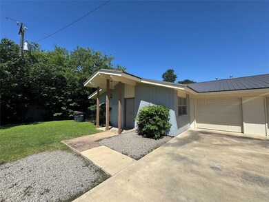View of front of property with a garage, brick si