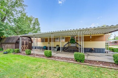 Rear view of house with a lawn and a storage unit