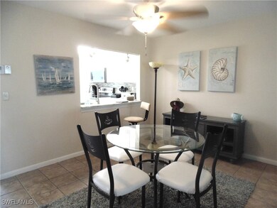 Tiled dining space with ceiling fan and baseboards