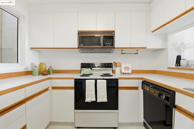 Kitchen featuring white cabinetry, electric stove, and dishwasher