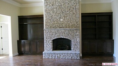 Family room w/ stacked stone fireplace. Built in b