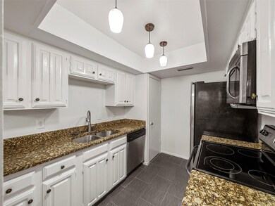Kitchen with white cabinets, appliances with stain