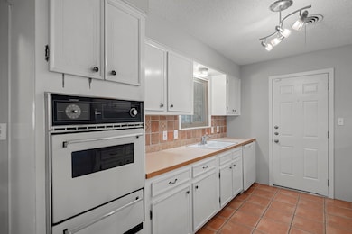 Kitchen with a sink, white appliances, a warming 