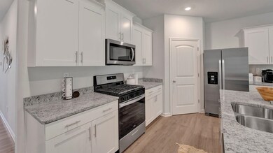 Kitchen with white cabinets, light wood-type floor