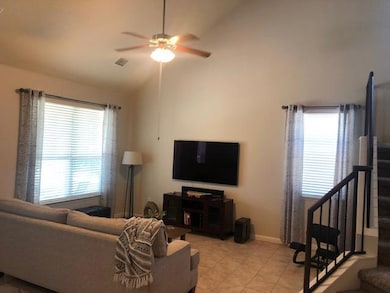 Living area featuring ceiling fan, stairway, high