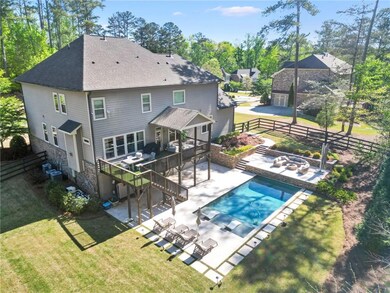 Rear view of house featuring roof with shingles, a patio area, cooling unit, an outdoor living space with a fire pit, and stairs