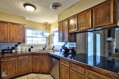 Kitchen featuring a textured ceiling, sink, decora