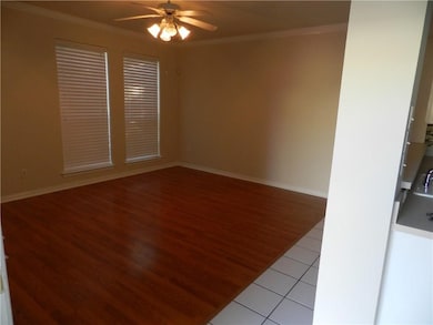 Unfurnished room featuring crown molding, light wood-style flooring, and ceiling fan