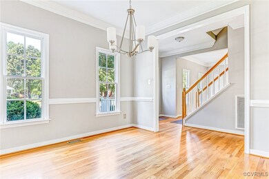 Empty room featuring crown molding, a healthy amount of sunlight, and light hardwood / wood-style floors