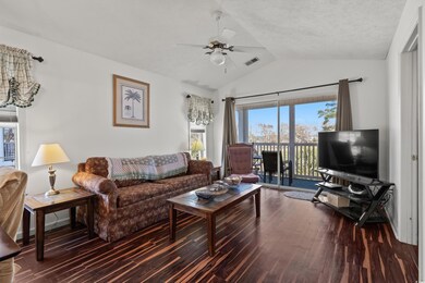 Living room featuring dark wood-type flooring, vau