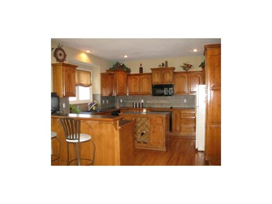 Kitchen with bar and island with wine rack.