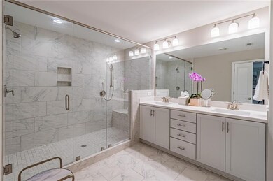 Bathroom featuring marble look tiles, double vanity, a stall shower, and recessed lighting