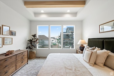 Primary bedroom with carpet and beamed ceiling