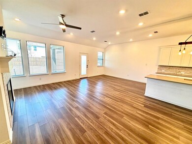 Unfurnished living room with a wealth of natural light, a fireplace, visible vents, and dark wood-type flooring