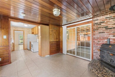 dining space with wood burner open to kitchen