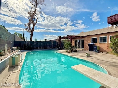 View of pool featuring a diving board, a patio area, a fenced backyard, and a pergola
