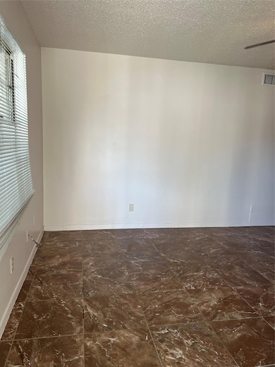 Empty room featuring a textured ceiling, visible 