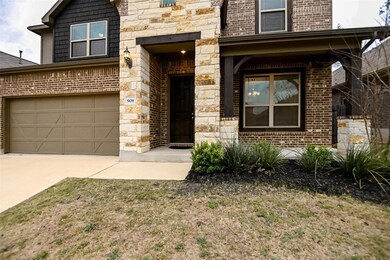 View of front facade with driveway, stone siding,