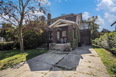 View of front of home featuring a chimney, a front yard, brick siding, and a patio