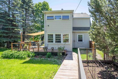 Rear view of property featuring a deck and a yard