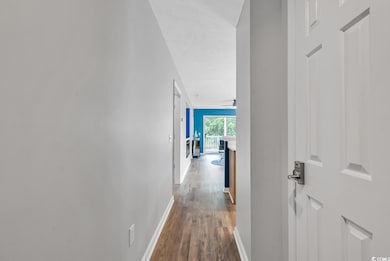 Corridor featuring baseboards and wood finished fl